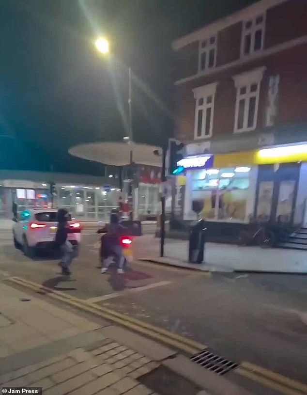 Two members of the group then sneak up behind a delivery rider before smashing two eggs on his helmet while he is on the move