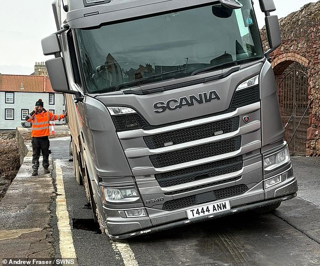 Lorry gets stuck after falling into sinkhole it was sent to repair - as road is closed for more than a month