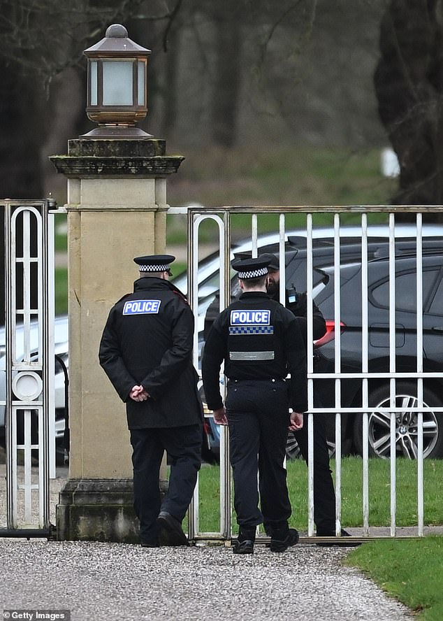 Police officers approach the gates of the Royal Lodge