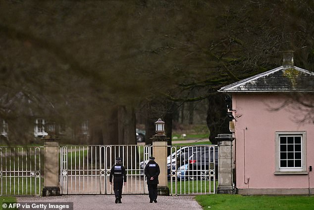 Police officers walk through the Bishops Gate entrance leading to Royal Lodge, a 30-room property and former residence to Andrew Mountbatten-Windsor