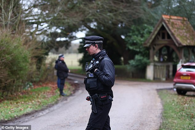 Police officers stand guard near the entrance to Wood Farm on Thursday