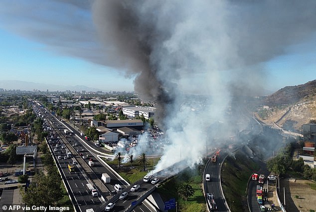 White gas cloud rising from the site of the fiery destruction that killed at least four people and left dozens injured