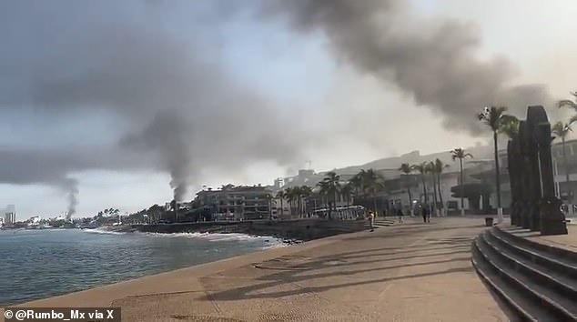 Columns of black smoke are pictured rising from Puerto Vallarta, a city popular with tourists. The chaos is thought to be in response to federal authorities killing a prominent cartel leader
