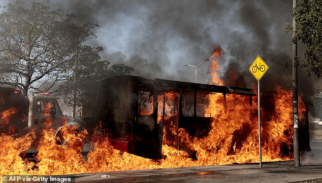 A bus set on fire by organised crime groups in response to an operation in Jalisco to arrest a high-priority security target, burns at one of the main avenues in Zapopan, state of Jalisco, Mexico, on February 22, 2026. Armed civilians blocked several roads in the state of Jalisco, in western Mexico, following an operation by federal forces in the town of Tapalpa, local authorities reported. Jalisco, which will host four matches of the upcoming 2026 World Cup, is home to the powerful Jalisco New Generation Cartel (CJNG), and has been rocked by several episodes of violence in recent years. (Photo by Ulises Ruiz / AFP via Getty Images)