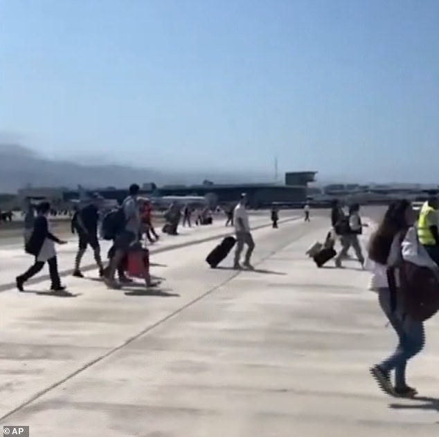 While no airports are closed, a majority of flights have been canceled and roadblocks are impacting airline operations. Travelers are seen on the runway at Puerto Vallarta airport