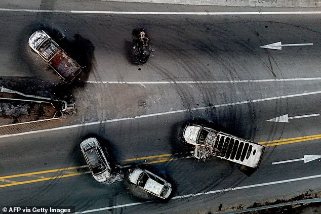 Burned cars and trucks, allegedly set on fire by organised crime groups in response to an operation to arrest a high-priority security target, on a highway near Acatlan de Juarez, Jalisco state