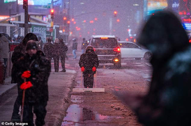 NEW YORK, NEW YORK - FEBRUARY 22: Workers shovel snow in Times Square on February 22, 2026 in New York City. A major winter storm is expected to hit the Northeast and Mid-Atlantic regions, bringing blizzard conditions with the potential for up to 23 inches of snow in New York City. A blizzard warning has been issued for large areas of the East Coast.  (Photo by Ryan Murphy/Getty Images)