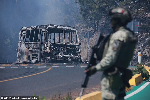 A soldier stands guard by a charred vehicle after it was set on fire, in Cointzio, Michoacán state, Mexico on Sunday, Feb. 22, 2026, following the death of Jalisco New Generation Cartel boss Nemesio Rubén Oseguera Cervantes