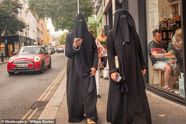 Two women dressed in burkas walking on King's Road in west London