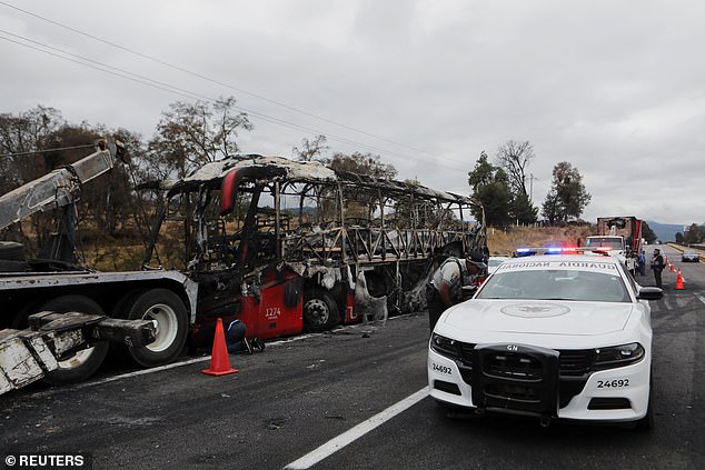 National Guard stood watch on the side of a highway connecting Mexico City with the state of Puebla after alleged cartel members set fire to a bus