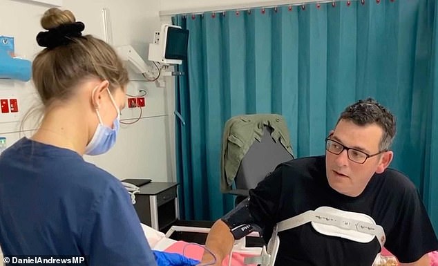 Dan Andrews is treated by medical staff after his fall in March 2021