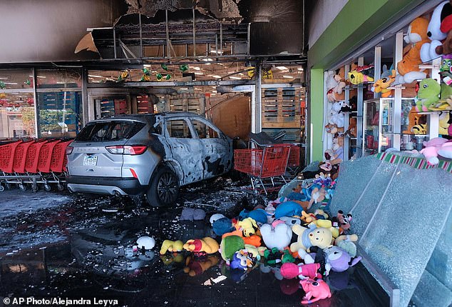 A charred vehicle sits at a damaged supermarket in Guadalajara, Jalisco state on Sunday