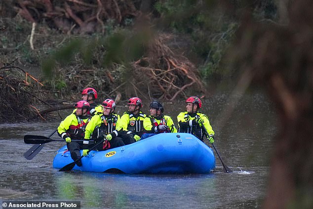 Officials ride a boat as they arrive to assist with a recovery effort at Camp Mystic last July