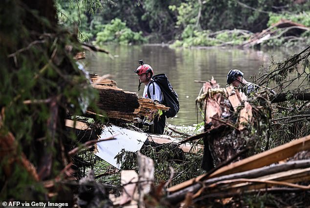 Members of a search and rescue team look for people near Camp Mystic last July. The camp announced plans to reopen at its Cypress Lake location for the 2026 season