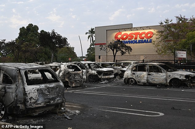 Burned cars are seen in the parking lot of a Costco retail store in Puerto Vallarta on Monday