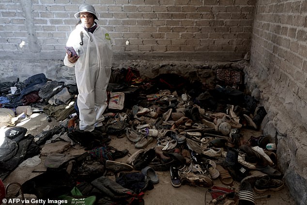 A woman records clothes and shoes found at the Izaguirre Ranch after the collective 'Guerreros Buscadores' visited the site in Teuchitlan last year