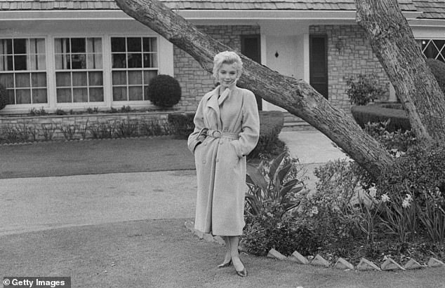 Monroe poses outside her home in 1962, it was the only property she ever purchased and owned by herself