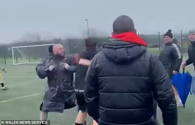 Moment brawl breaks out between parents at under 14s football match as children are forced to pull adults apart