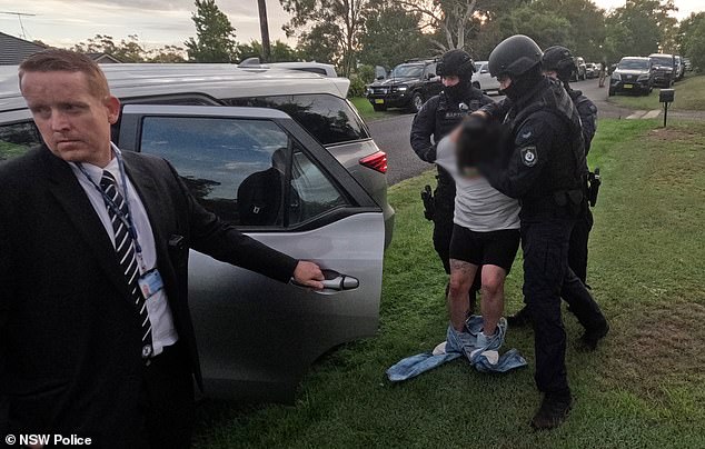 The alleged kidnapper and killer's jeans fell around his ankles as he was dragged off (pictured)