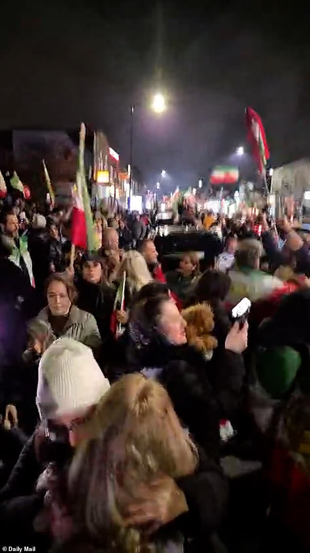 London street brought to a standstill as jubilant people blare music, hand out roses, and wave Iranian flags to celebrate the death of Ayatollah Ali Khamenei