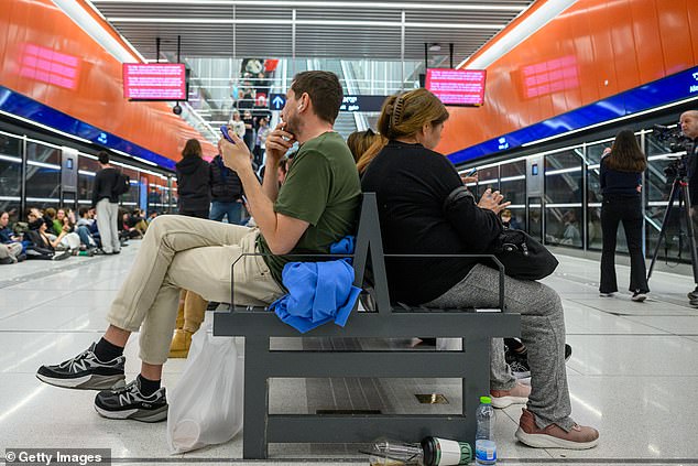 People take cover in an underground light rail station amid reports of incoming missiles in Israel