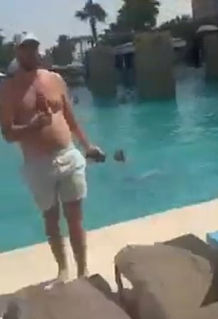 A man wearing swimming trunks at the side of the pool while strikes are intercepted above
