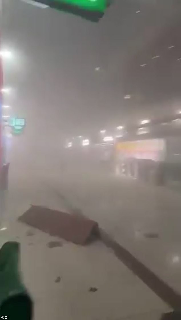 The terminal at Dubai International Airport is seen covered in smoke after being hit by an Iranian drone