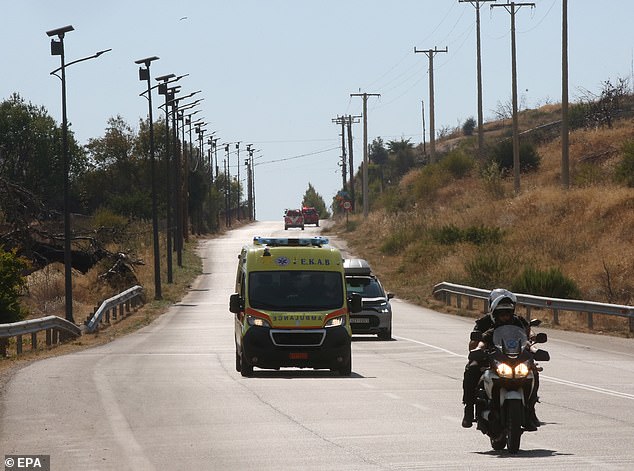 An ambulance is seen heading to the area where two firefighting helicopters crashed in Psatha, during a fire in the wider region of Megara