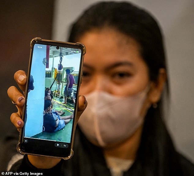 A woman shows footage of her husband aboard the burning vessel as she waits for updates