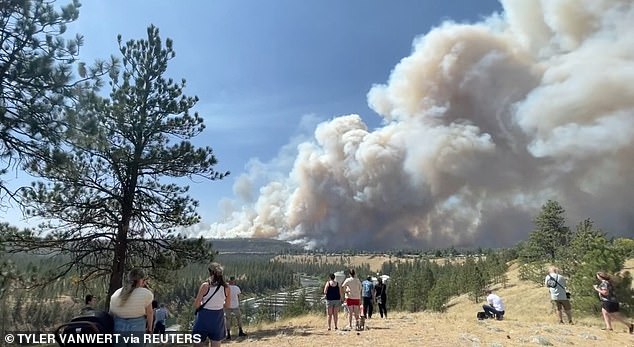 Onlookers watch as massive plumes of smoke rise from a wildfire in Spokane, US, August 1, 2026