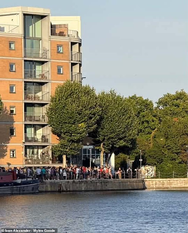 A crowd is seen gathered at the scene. Emergency services were called just before 7pm yesterday after reports that a boy had got into difficulty in the water
