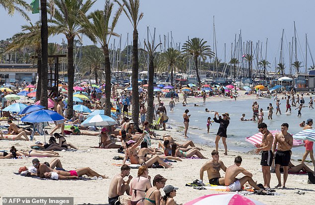 Tourists gather on Palma's Beach in Palma de Mallorca last year