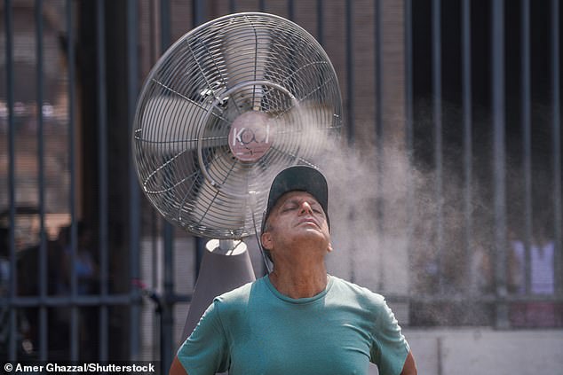 A tourist cools down using a misting fan at the Colosseum in Rome on August 3, 2026