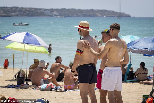 Tourists apply sunscreen at Palma's Beach in Palma de Mallorca in 2025