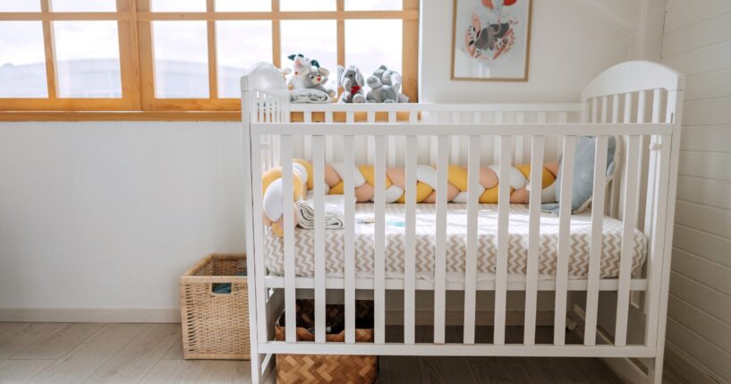 A baby crib in a modern cozy bedroom.