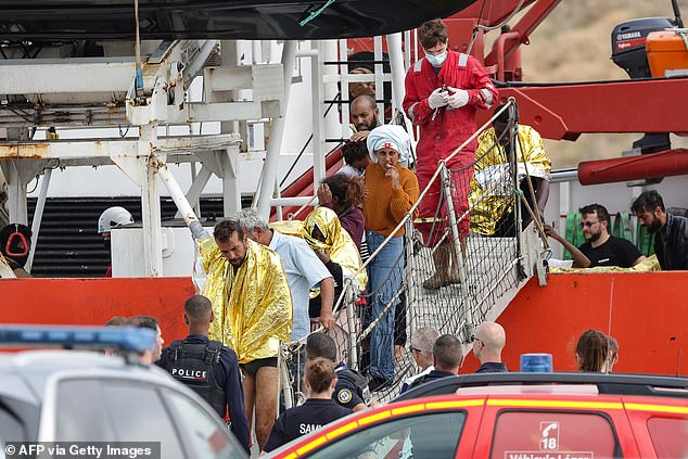 Some of the rescued migrants wore gold thermal jackets to warm them up after ending up in the sea