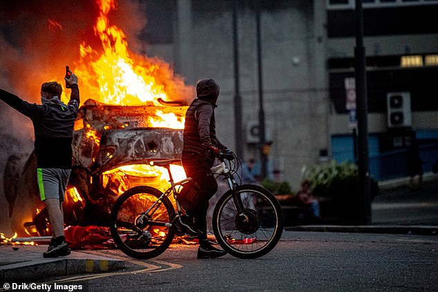 A police car is set on fire in Sunderland during protests held in the wake of the Southport murders