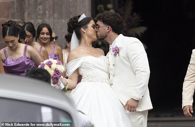 The bride and groom share a kiss in front of an unexpectedly huge crowd in Madeira