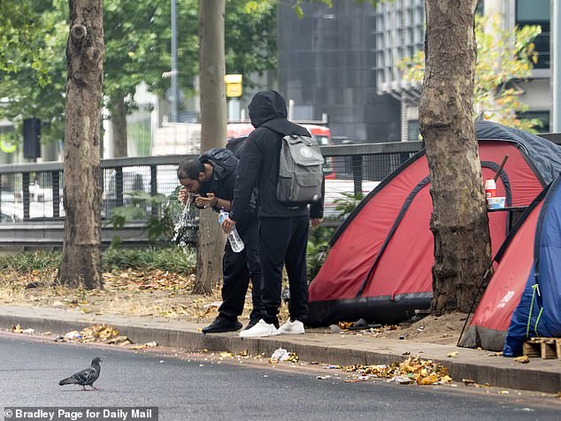 When the Daily Mail visited, we saw squatters waking up and carrying out their morning routines ¿ bathing (pictured), brushing their teeth and washing pans