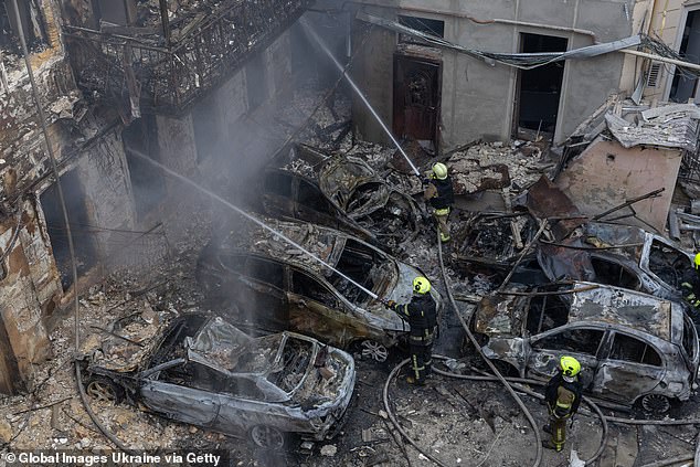 Ukrainian firefighters hose down a building on August 9, 2026 in the aftermath of a Russian strike on a residential building in Odesa