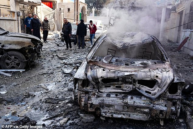 People check the damage at the scene of a Syrian regime airforce strike that targeted a neighbourhood in Syria's rebel-held northern city of Idlib on December 1, 2024