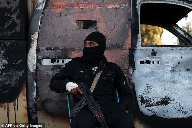 A member of the security forces loyal to the interim Syrian government guards a checkpoint previously held by supporters of deposed president Bashar al-Assad, in the town of Ayn Shiqaq, in the coastal province of Latakia, on March 11, 2025