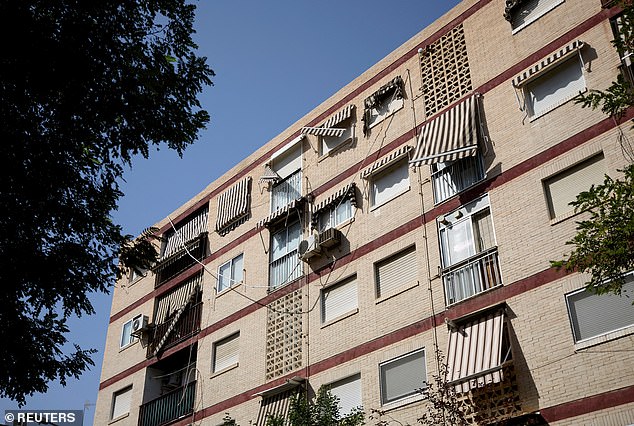 Damaged awnings hang from the wall of an apartment complex