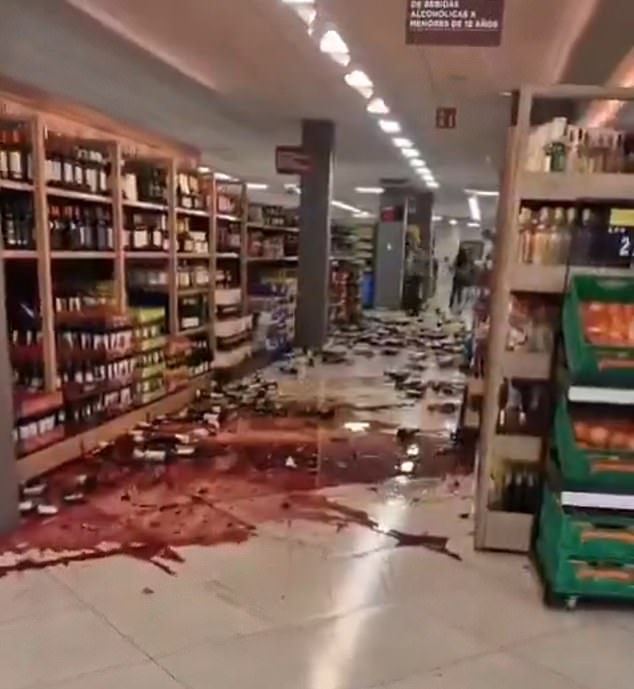 Wine and other products are spilled over the floor of a supermarket in the city