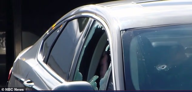 A bullet hole can be seen in the passenger side of the vehicle