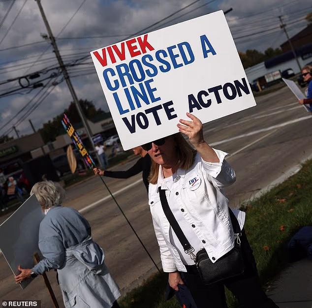 Demonstrators held up signs as the 2026 Ohio Republican Bus Tour passed by after a campaign event with Ohio gubernatorial Republican candidate Vivek Ramaswamy