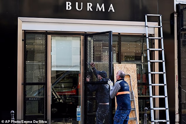 Worker install safeguards on a shop before protests are expected to begin on Saturday