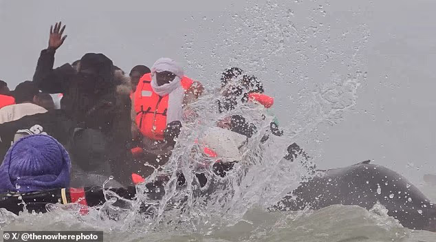 A small boat in France is seen dipping into the water and nearly capsizing as enraged migrants fight each other for a space