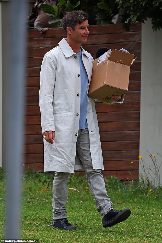 He opted for a long white trenchcoat, grey jeans and black shoes...