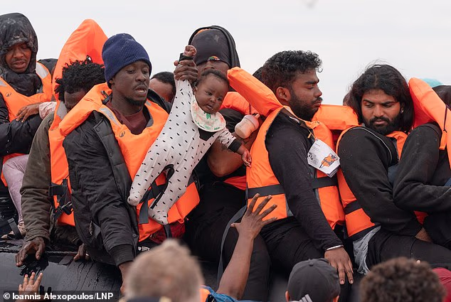 A migrant holds a baby on a small boat on a beach in Eccault, France, in August this year. Since January, thousands of child migrants have made the 21 mile crossing, with no fewer than 2,182 making the trip entirely alone - more than 200 a month